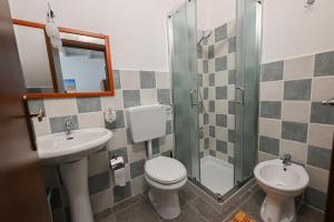 a bathroom with a toilet and a sink and a shower at B&B Su Neulagi in Triei