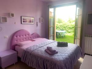 sypialnia z różowym łóżkiem i 2 ręcznikami w obiekcie Appartamento Valdichiana w mieście Bettolle