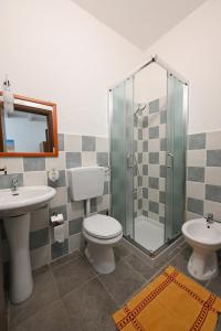 a bathroom with a toilet and a sink and a shower at B&B Su Neulagi in Triei