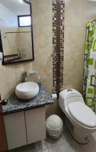 a bathroom with a toilet and a sink and a mirror at Casa D'Lucas in Puerto Baquerizo Moreno