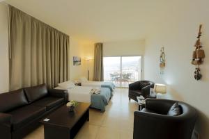 a living room with a couch and a living room with a couch at Rabiya Marine Hotel in Ţabarjā