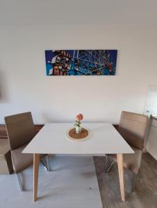 einen weißen Tisch mit Stühlen und ein Gemälde an der Wand in der Unterkunft Jezza Apart Suite in München