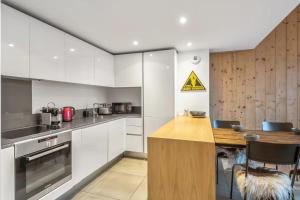 cocina con armarios blancos y encimera de madera en Résidence Luxe 5*,Spa & Fitness, La Cordée Appartement 214, en Chamonix-Mont-Blanc