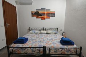 a bedroom with a bed with blue towels on it at B&B Su Neulagi in Triei