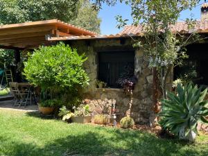 a stone house with plants in the yard at Chalet Valdevaqueros - Gran piscina y 5 min playa in Tarifa