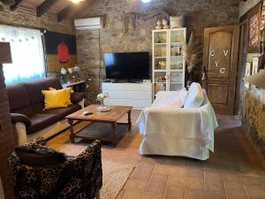 a living room with a couch and a tv at Chalet Valdevaqueros - Gran piscina y 5 min playa in Tarifa