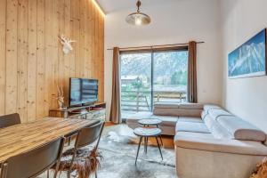 sala de estar con sofá y mesa en Résidence Luxe 5*,Spa & Fitness, La Cordée Appartement 214, en Chamonix-Mont-Blanc
