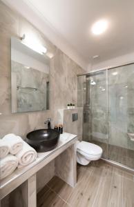 a bathroom with a sink and a shower and a toilet at 180 Villas in Nydri +57 photos