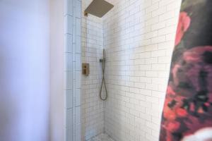 a bathroom with a shower with white tiles at Sugar's INN Room #6 King Bed in Galveston