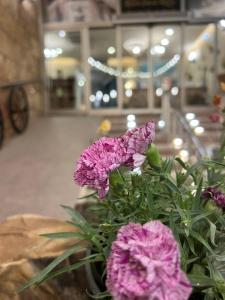 un vaso pieno di fiori viola su un tavolo di Khan Saray a As Sulaymānīyah