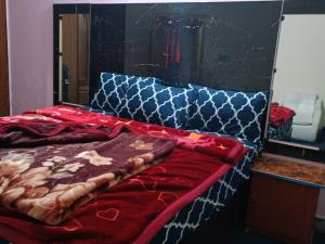 1 cama con manta roja y espejo en Hotel Moon Light view, en Lahore 15 fotos más