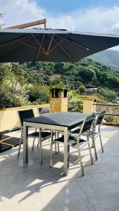 een tafel en stoelen op een patio met een parasol bij Casa Virginia in Maracalagonis