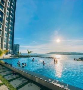 a group of people in the infinity pool of a hotel at SEAVIEW LUXURY CONDO HOMESTAY 2Bed 2bath Jesselton Quay by R2 Residence in Kota Kinabalu