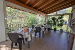 een eetkamer met tafels en stoelen op een patio bij B&B Su Neulagi in Triei