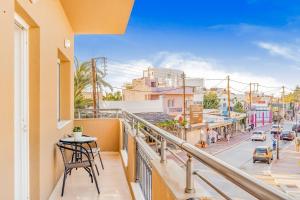 balkon ze stołem i widokiem na ulicę w obiekcie Maela Luxury Suite w mieście Malia