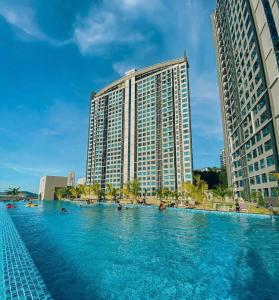 a large swimming pool in front of a tall building at SEAVIEW LUXURY CONDO HOMESTAY 2Bed 2bath Jesselton Quay by R2 Residence in Kota Kinabalu