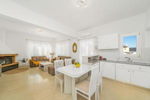 cocina y sala de estar con mesa y sillas en Maela Luxury Suite en Mália