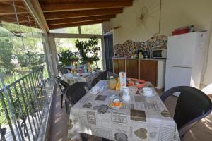 een keuken met een tafel en stoelen op een balkon bij B&B Su Neulagi in Triei