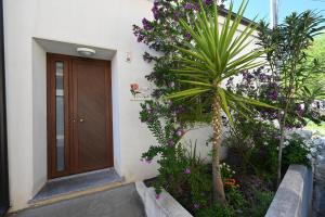 a front door of a house with purple flowers at B&B Su Neulagi in Triei