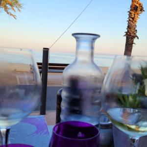 een fles wijn en twee glazen op een tafel bij Mobile-home hyeres var climatisé dans camping avec piscine jusqu'à 6 personnes in Hyères