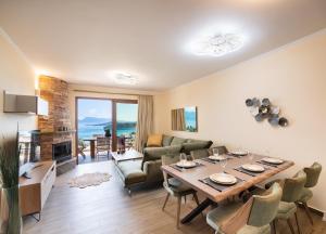 - un salon avec une table, des chaises et une cheminée dans l'établissement 180 Villas, à Nydri