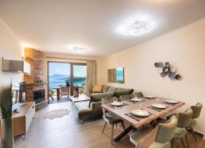 a living room with a table and chairs and a fireplace at 180 Villas in Nydri