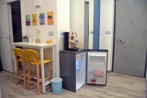 a kitchen with a refrigerator and a table and chairs at Room&Chiaia in Naples