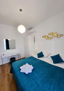 a room with a bed with a blue blanket and a tv at Apartments Miljas 2 in Dubrovnik