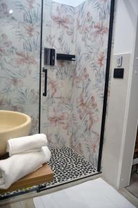 a bathroom with a shower with pink flowers at Room&Chiaia in Naples +27 photos