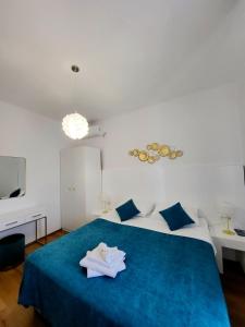 a bedroom with two beds and a blue blanket at Apartments Miljas 2 in Dubrovnik