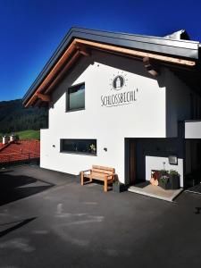 a white building with a bench in front of it at Schlossbichl in Nauders