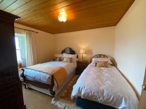 1 dormitorio con 2 camas y techo de madera en North Farm en Hexham