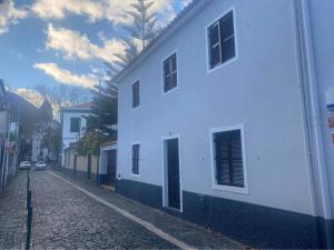 a white building on a cobblestone street at The Village House in Machico