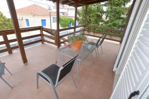 een patio met een tafel en stoelen op een veranda bij Bright and airy home 50 meters from the beach in Xylokastron