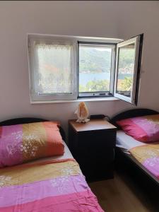 a bedroom with two beds and two windows at Apartment Danja in Kamenari