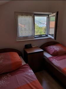 a small room with two beds and two windows at Apartment Danja in Kamenari