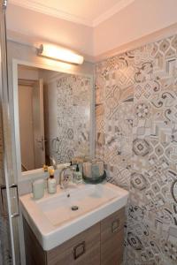 een badkamer met een wastafel en een spiegel bij Bright and airy home 50 meters from the beach in Xylokastron