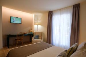 アグア・アマルガにあるmiKasa Agua Amarga & SPAのベッド、デスク、窓が備わるホテルルームです。