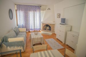 a living room with a couch and a fireplace at Althea Archontika Tis Androu in Batsi