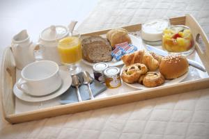 uma bandeja de alimentos e bebidas de pequeno-almoço numa cama em Hôtel de France em Aix-en-Provence