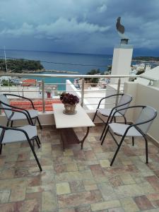 einen Tisch und Stühle auf einem Balkon mit Meerblick in der Unterkunft Votsi Seaview in Alonnisos Altstadt