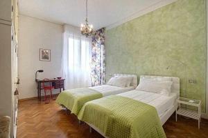 una camera da letto con un grande letto bianco con una coperta verde di Frati Bigi With Two Bedrooms And Parking a Firenze