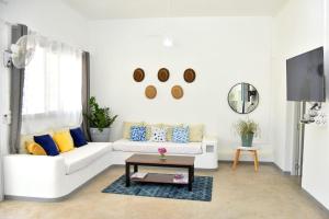 ein Wohnzimmer mit einem weißen Sofa und einem Couchtisch in der Unterkunft Mykolodge Majunga in Amborovy