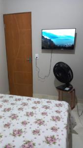 una camera con letto e TV a schermo piatto di Casa Confortável a Caruaru