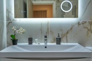 a white sink in a bathroom with a mirror at Luxury Stylish 2 Beds / 2 Baths in London