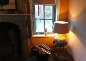 a lamp sitting on a table next to a window at Fakânsjehûs Sfeervol met fijne tuin in Irnsum