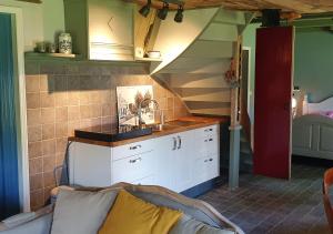 a kitchen with a sink and a staircase at Fakânsjehûs Sfeervol met fijne tuin in Irnsum +12 photos