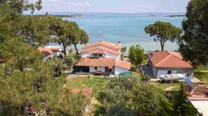 a house with a view of the water at Docker 2 Beachfront Villa Vourvourou by Halkidiki Villas in Vourvourou