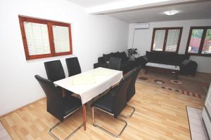 a dining room with a table and black chairs at Apartman Komfor in Banja Luka