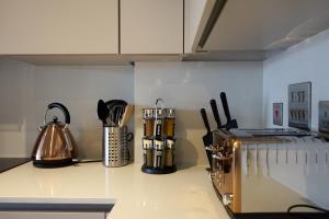 - un comptoir de cuisine avec une bouilloire et des ustensiles dans l'établissement Luxury Stylish 2 Beds / 2 Baths, à Londres